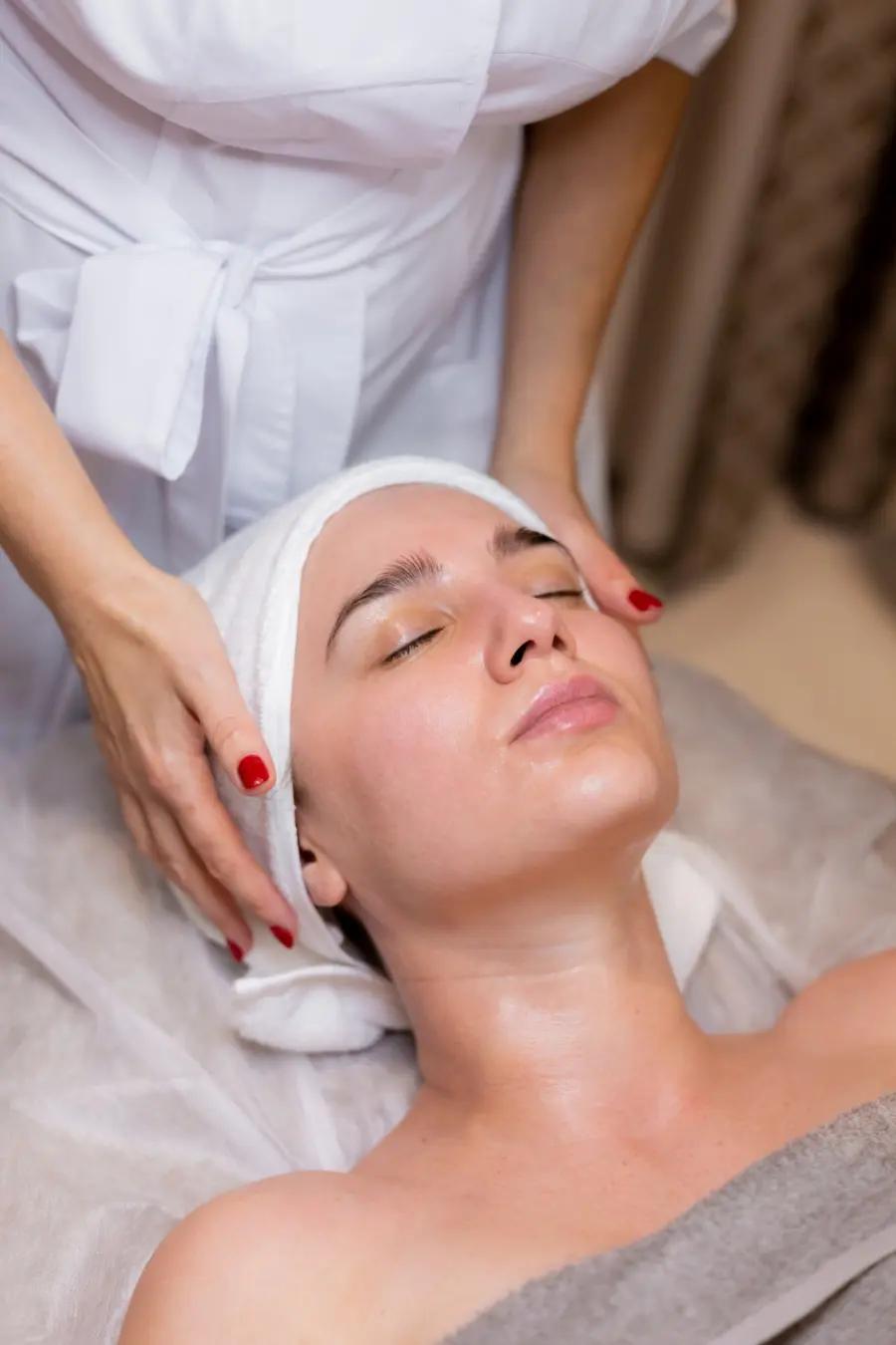 Woman with a white towel wrapped around her hair relaxing